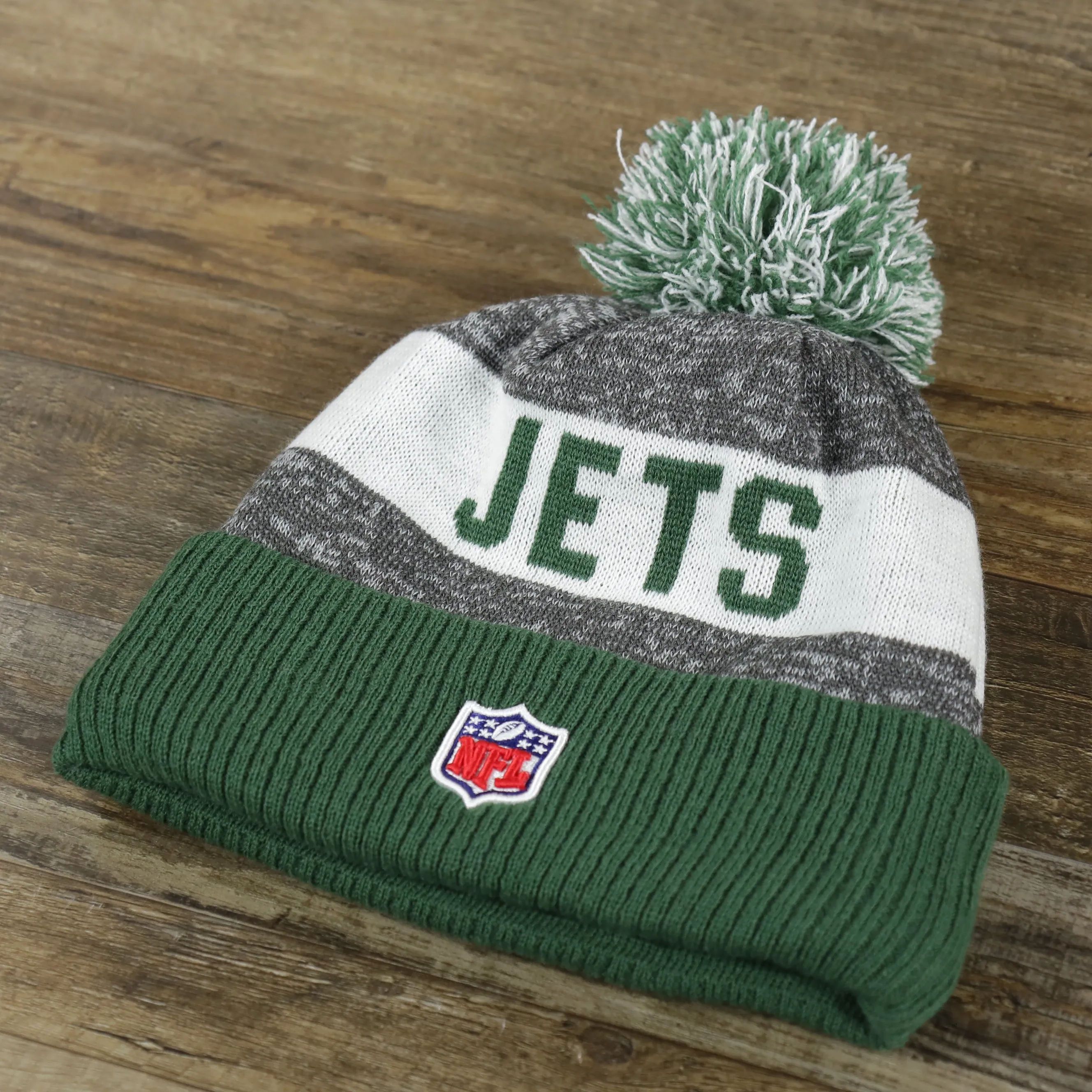 New York Jets Pom Pom Winter Beanie - Green and Gray, On-Field Striped Wordmark.